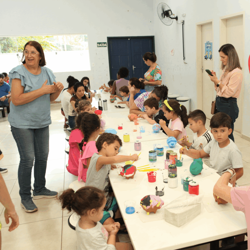Crianças e adultos fazendo bolsas sobre uma mesa branca